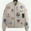 Kith Olympics Heritage Marvin Bomber Jacket front view featuring embroidered Olympic logos from various years on an off-white base.
