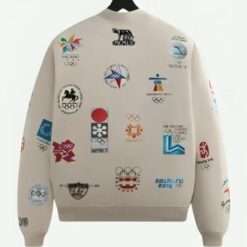 Kith Olympics Heritage Marvin Bomber Jacket back view displaying multiple embroidered Olympic logos across a vintage-inspired off-white fabric.