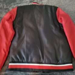 Back view of the Marvel Spider-Man Miles Morales Color Blocked Jacket, showcasing a sleek black and red design with striped cuffs and hem.