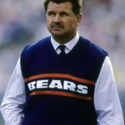 Mike Ditka wearing a classic Chicago Bears sweater vest in navy blue with bold 'BEARS' lettering and orange stripes.