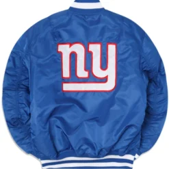 New York Giants X Alpha X New Era MA-1 Bomber Jacket showcasing a bold 'NY' logo in red and white on a royal blue satin finish.