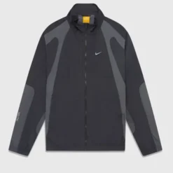 OVO Nocta Northstar Nylon Track Jacket front view – black with dark grey paneling, Nike swoosh logo, and zip-up closure.