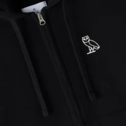 Close-up of embroidered owl logo on black OVO Relaxed-fit Fleece Hoodie.