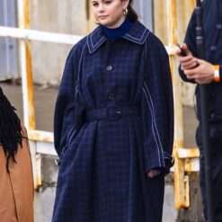Selena Gomez wearing a navy blue plaid trench coat with a belted waist in Only Murders in the Building (2021).