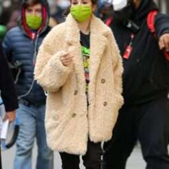 Selena Gomez wearing a beige fur coat while walking on the set of "Only Murders in the Building.