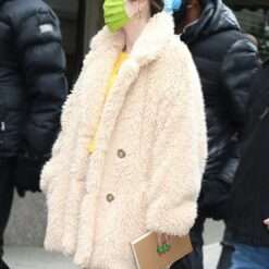 Selena Gomez in a cozy beige fur coat, carrying a book, while filming "Only Murders in the Building.