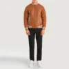 Pascal Tan Brown Leather Varsity Jacket front view, featuring a sleek zip-up design, ribbed collar, and striped cuffs.