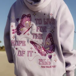 A close-up back view of the lilac "Pink Palm Puff To Live For the Hope of it All" hoodie, featuring a butterfly and quote design.
