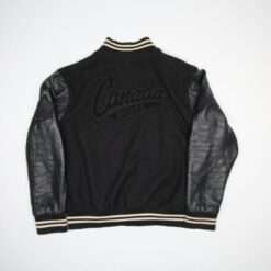 Back view of a black varsity jacket with "Canada Roots" embroidered in tonal stitching.