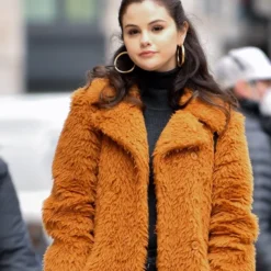 A close-up view of Selena Gomez in a brown fur coat from "Only Murders in the Building," highlighting its plush texture.