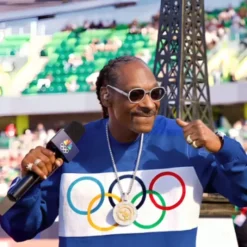 A closeup of Snoop Dogg’s blue Olympic Trials tracksuit, highlighting the Olympic rings logo and details of the sweatshirt.