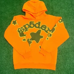 Sp5der Beluga Hoodie in vibrant orange with bold green star graphics and Sp5der branding.