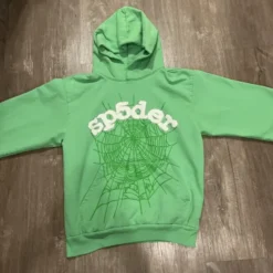 Sp5der Light Green Web Hoodie featuring a white "Sp5der" logo with rhinestone detailing and an embossed green spiderweb design on the front.
