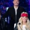 Ryan Seacrest on American Idol Season 23 dons a suede bomber jacket, combining sleek sophistication with a touch of casual style, perfect for his on-stage presence.