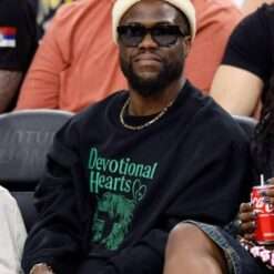 Kevin Hart attends a Los Angeles Clippers game wearing a black sweatshirt, showcasing a relaxed and casual look with a sporty edge perfect for courtside style.
