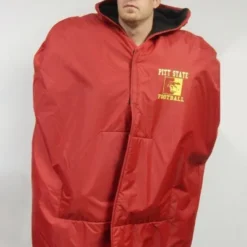 NFL Sideline Cape Coat featuring a weather-resistant outer shell, oversized fit with a hood, team logo on the chest, and snap-button front for easy wear on game days.