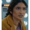 Varada Sethu wearing a golden yellow trench coat from Doctor Who Season 15 – eye-catching women's outerwear featuring a long tailored silhouette, wide lapels, and belted waist.
